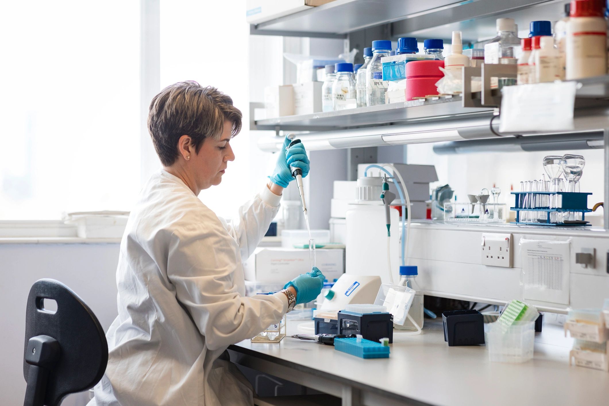 Research scientist working with precision lab tools in a biomedical laboratory